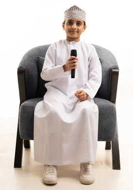 Omani Boy in Traditional Dress Holding a Microphone