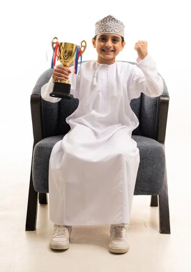 Omani Boy Holding Gold Trophy Success Studio Shot