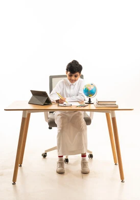 Saudi Boy Studying at Desk with Tablet and Globe