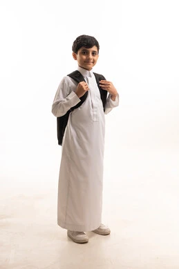Saudi Schoolboy in Traditional White Thobe and Backpack