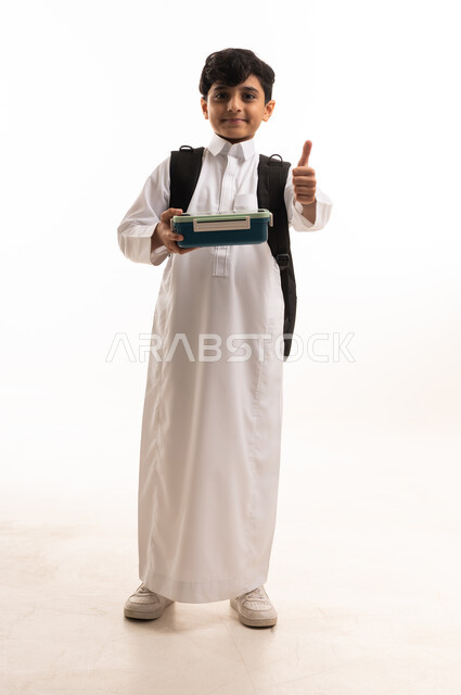 طالب سعودي بالثوب التقليدي يحمل صندوق الغداء
