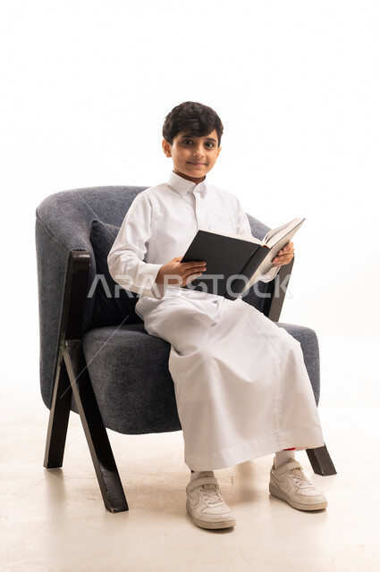 Saudi Boy in White Thobe Reading a Book