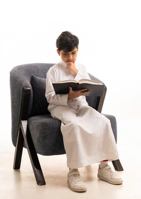 Saudi Boy Reading Book in White Thobe