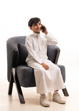 Saudi Boy in White Thobe Talking on Smartphone