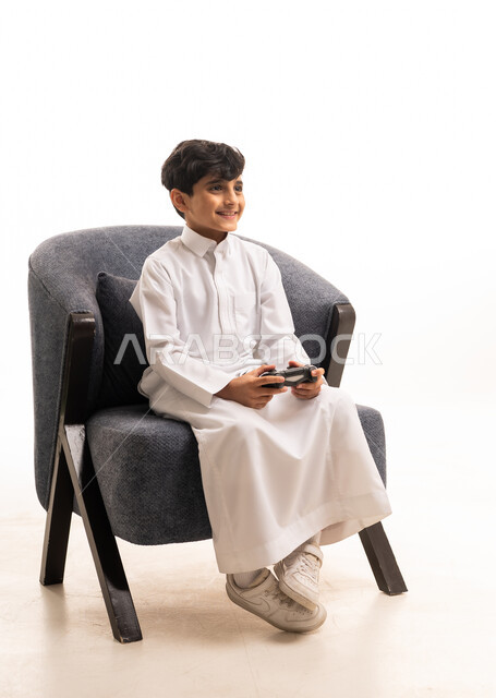 طفل سعودي بالثوب التقليدي يلعب ألعاب الفيديو