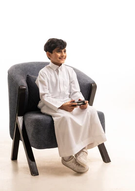 Saudi Boy in Traditional Thobe Playing Video Games