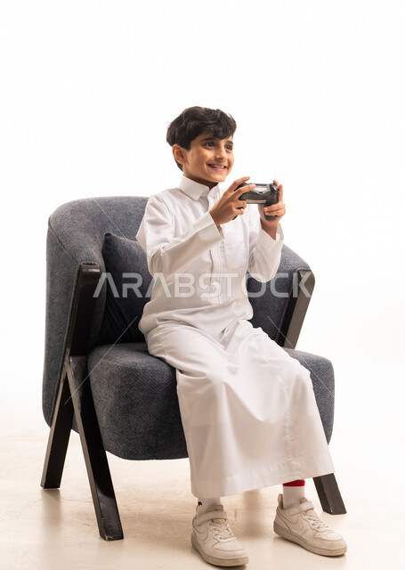 طفل سعودي بالثوب الأبيض يلعب ألعاب الفيديو