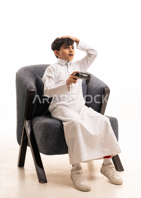 طفل سعودي بالثوب التقليدي يلعب ألعاب الفيديو