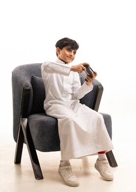 Saudi Boy Playing Video Games in Traditional Thobe