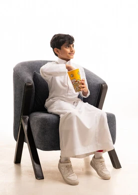 Saudi Boy in White Thobe Eating Popcorn in Studio