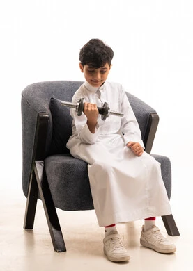 Saudi Boy in White Thobe Lifting Dumbbell
