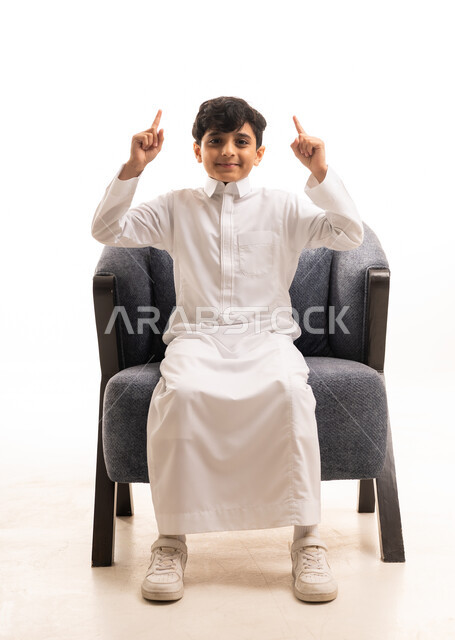 طفل سعودي بالثوب الأبيض يشير للأعلى