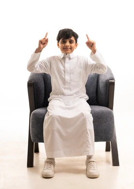 طفل سعودي بالثوب الأبيض يشير للأعلى