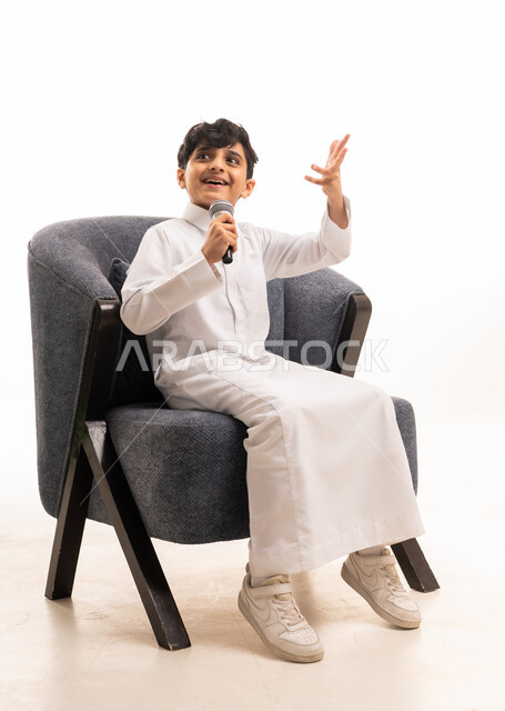 Saudi Boy in Traditional Thobe Holding Microphone