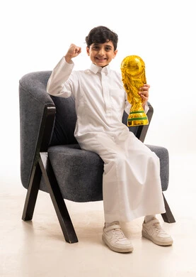 Saudi Boy in Thobe Holding World Cup Trophy