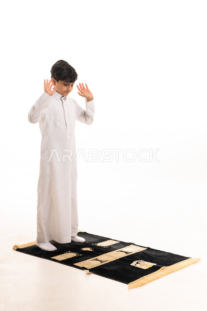 Saudi Boy Praying in White Thobe on Prayer Mat