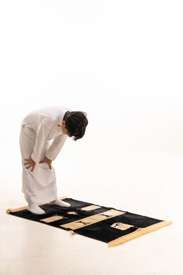 Saudi Boy in White Thobe Praying Ruku on White Background