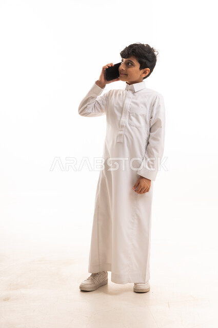 Saudi Boy in Traditional Thobe Using Smartphone Studio Shot