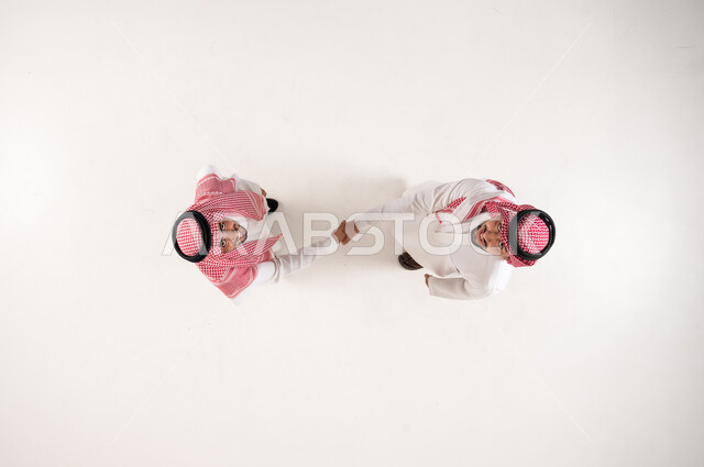 Saudi Men Handshake Overhead View on White Background