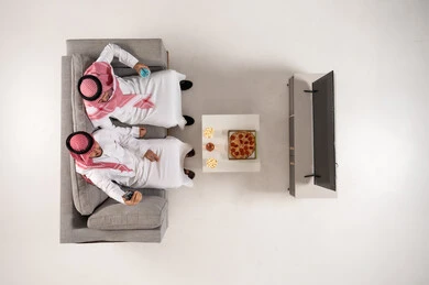 Saudi Men Watching TV with Pizza Top View