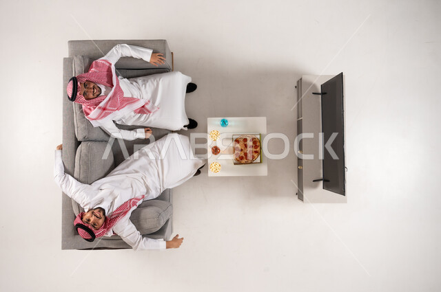 رجال سعوديون بالزي التقليدي مع بيتزا من منظور علوي