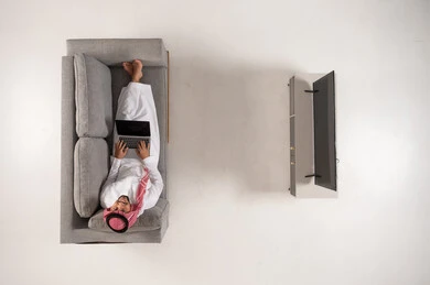 Saudi Man on Sofa with Laptop Top View