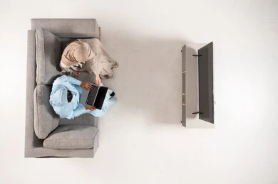 Emirati Couple Using Laptop on Sofa Top View