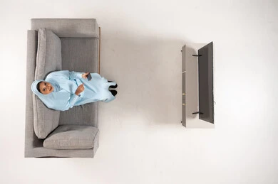 Saudi Woman on Sofa with Smartphone Top View