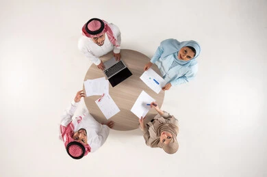اجتماع موظفين سعوديين حول طاولة مستديرة منظر علوي