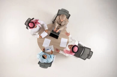 Saudi Professionals Meeting Around Table Overhead View