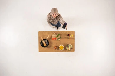 Arab Woman with Smartphone at Kitchen Table Top View Arab Woman with Smartphone at Kitchen Table Top View