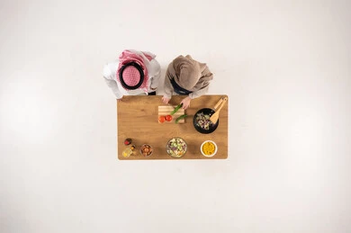 Saudi Couple Preparing Food Overhead View on White