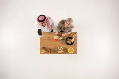 Saudi Couple with Smartphone in Kitchen Overhead View