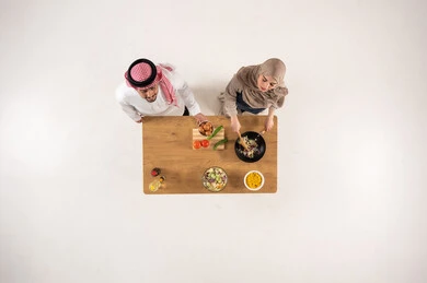 Saudi Couple Cooking at Table Overhead View Saudi Couple Cooking at Table Overhead View