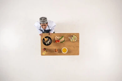 Omani Man Cooking at Wooden Table Overhead View
