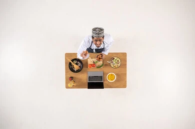 Omani Man Cooking with Laptop Top View