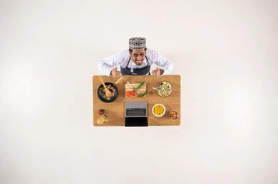 Omani Man in Traditional Dress Cooking at Table