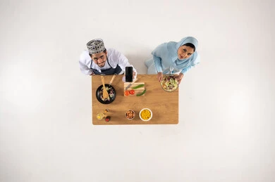 زوج عماني يطبخ مع هاتف ذكي لقطة علوية