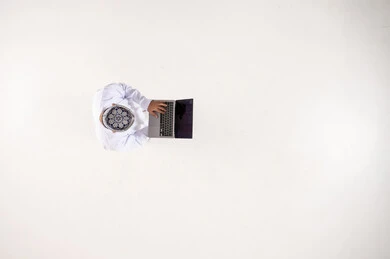 Omani Man in Traditional Dress Using Laptop Top View