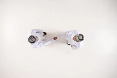 Omani Men Shaking Hands in Traditional Dress Overhead View