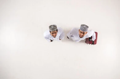 Omani Men in Traditional Dress with Travel Suitcase