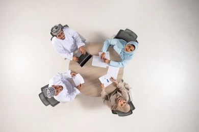 Omani Business Professionals Meeting with Laptop Top View