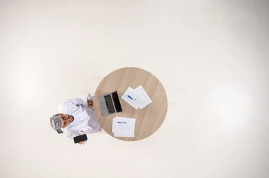 Omani Man at Desk Top View with Technology