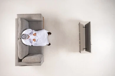 Omani Man in Traditional Dress Sitting on Sofa Top View