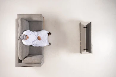 Omani Man in Traditional Dress Watching TV Top View