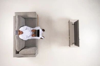 Omani Man Using Laptop on Sofa Top View