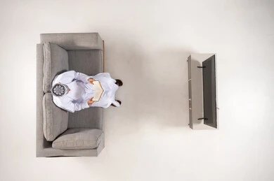 Omani Man Reading Book on Sofa Overhead View