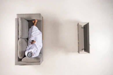Omani Man Using Smartphone on Sofa Top View