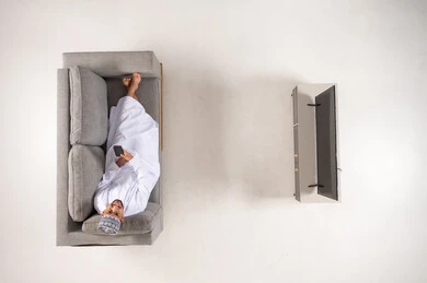 Omani Man Using Smartphone on Sofa Overhead View