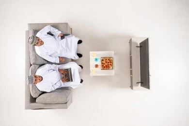 Omani Men in Traditional Dress Using Laptop at Home